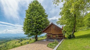 Une cabane en bois avec une allée pavée, entourée d’une végétation luxuriante et offrant une vue pittoresque.