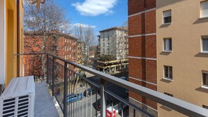 A balcony with a view of a cityscape, including buildings and a street.