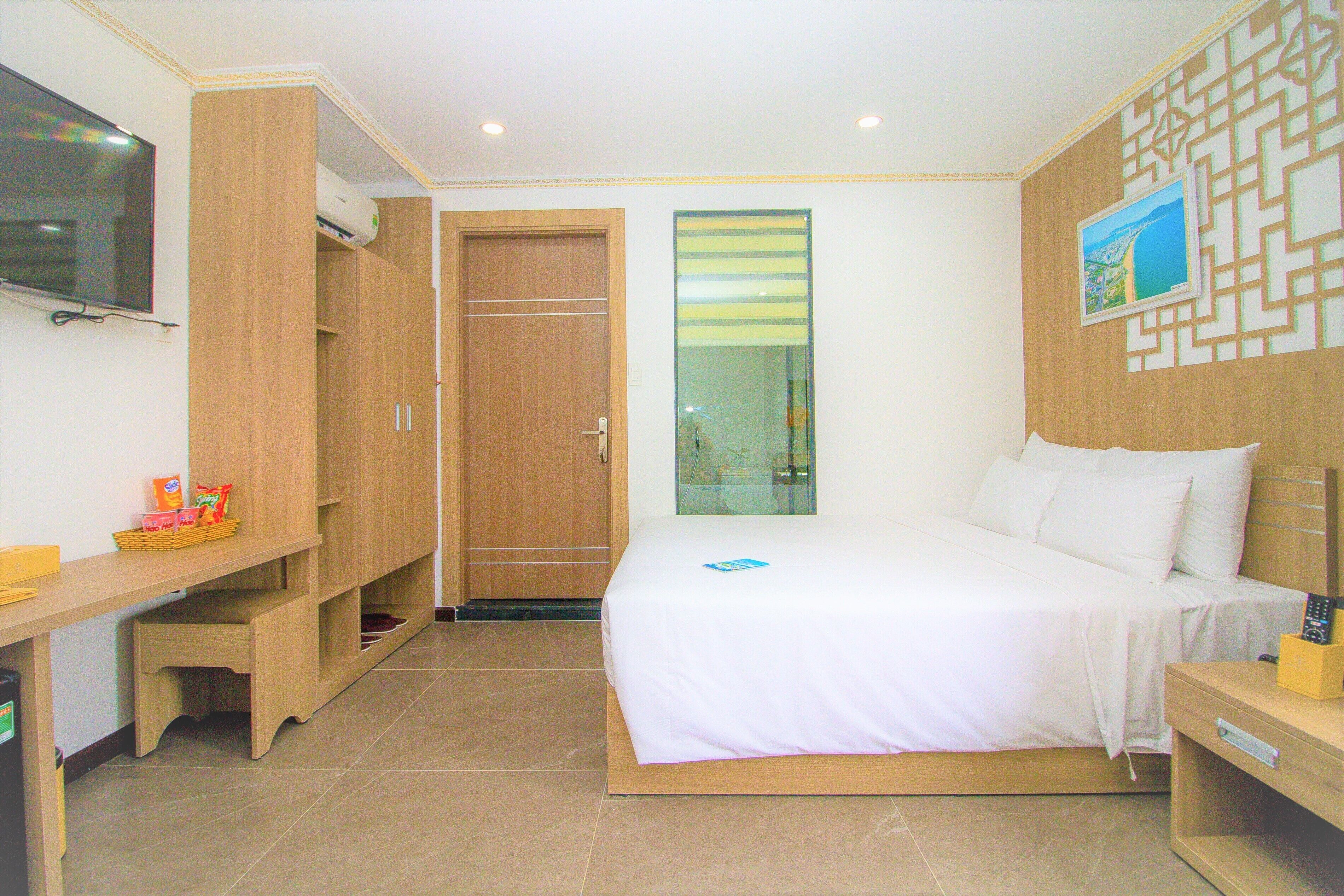 Ein Hotelzimmer mit Bett, Schreibtisch, Fernseher und Kleiderschrank.