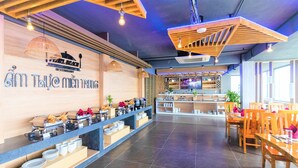 A restaurant with a buffet setup, wooden ceiling, and tiled floor. - Pearl Beach Hotel Quy Nhon (Quy Nhon Dong)