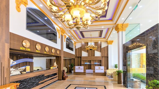 A hotel lobby with a grand chandelier, reception desks, and a marble floor. - Pearl Beach Hotel Quy Nhon (Quy Nhon Dong)