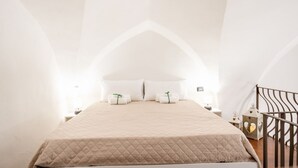 A bedroom with a bed, pillows, a nightstand, and a decorative lantern.