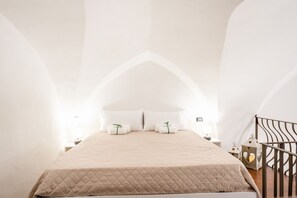 A bedroom with a bed, pillows, a nightstand, and a decorative lantern.