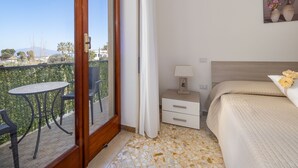 A hotel room with a balcony, a bed, a nightstand, and a view of the mountains. - ENEA - Sorrento Center with seaview (Sorrento)