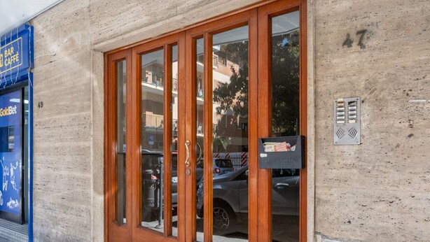 A building entrance with a wooden door, a mailbox, and a blue sign on the left. - ENEA - Sorrento Center with seaview (Sorrento)