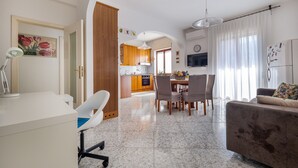 A modern living room with a dining area, kitchen, and a white desk with a lamp. - ENEA - Sorrento Center with seaview (Sorrento)