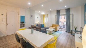 A modern living room with a dining area, a sofa set, a coffee table, and a view of the outside. - Bright, Clean & Very Comfortable Apartment (Valencia)
