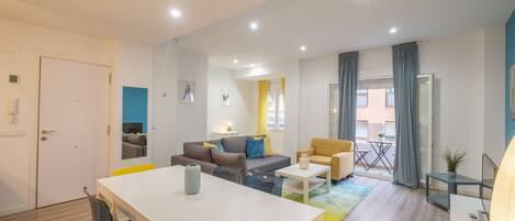 A modern living room with a dining area, a sofa set, a coffee table, and a view of the outside.