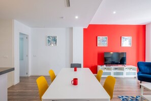 A modern living room with a white table, yellow chairs, a red accent wall, and a blue sofa. - § Spacious & Clean Apartment in Quiet Area § (Valencia)