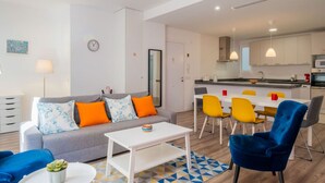 Een modern appartement met een woonkamer, eethoek en keuken.