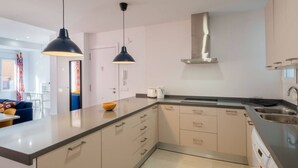 A modern kitchen with a large island, pendant lights, and a stainless steel range hood. - Spacious Clean & Colourful Apt Quiet Zone (Valencia)