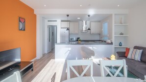 A modern apartment with a kitchen, dining area, and living room.