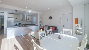 A modern apartment with a kitchen, dining area, and living room.