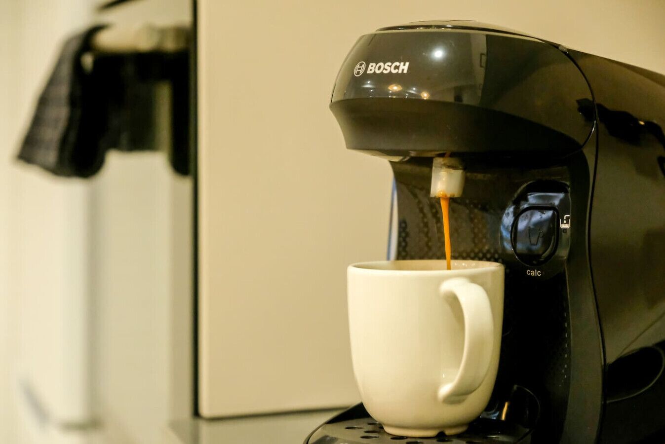Une machine à café en train de verser du café dans une tasse.