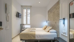 A modern bedroom with a large bed, a chair, a TV, and a window with a view. - ≼ Clean & Cozy Room close to City Centre ≽ (Valencia)