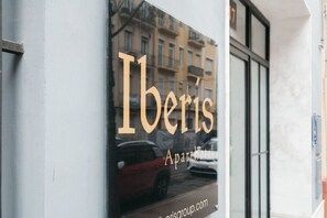 A window with the text "Iberis Aparthotel" and a reflection of a car.
