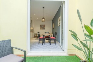 A dining area with a table and chairs, a hanging light fixture, and a door leading to another room.