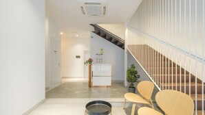 A modern reception area with a staircase, a reception desk, and seating. - ꕥ Chic & Comfortable Apartment/ Private Terrace ꕥ (Valencia)
