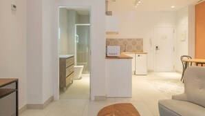 Un appartement moderne comprenant une cuisine, un coin repas et une salle de bain avec une douche à parois de verre.