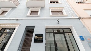 Un immeuble avec une enseigne indiquant « Iberis Apartment » et une grande fenêtre portant le numéro « 17 ».