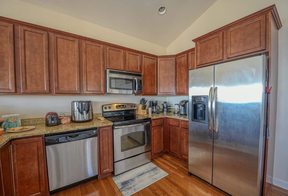 A kitchen with wooden cabinets, stainless steel appliances, and granite countertops.
