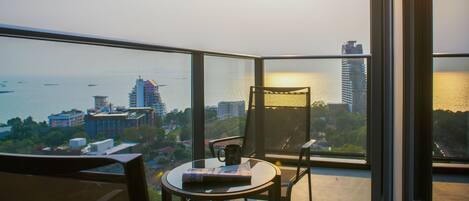 A balcony with a table, chairs, and a newspaper.