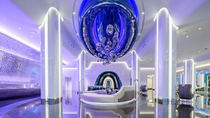 A modern lobby with a central seating area, a reflective ceiling feature, and a patterned wall. - Grande Centre Point Space Pattaya (Pattaya)