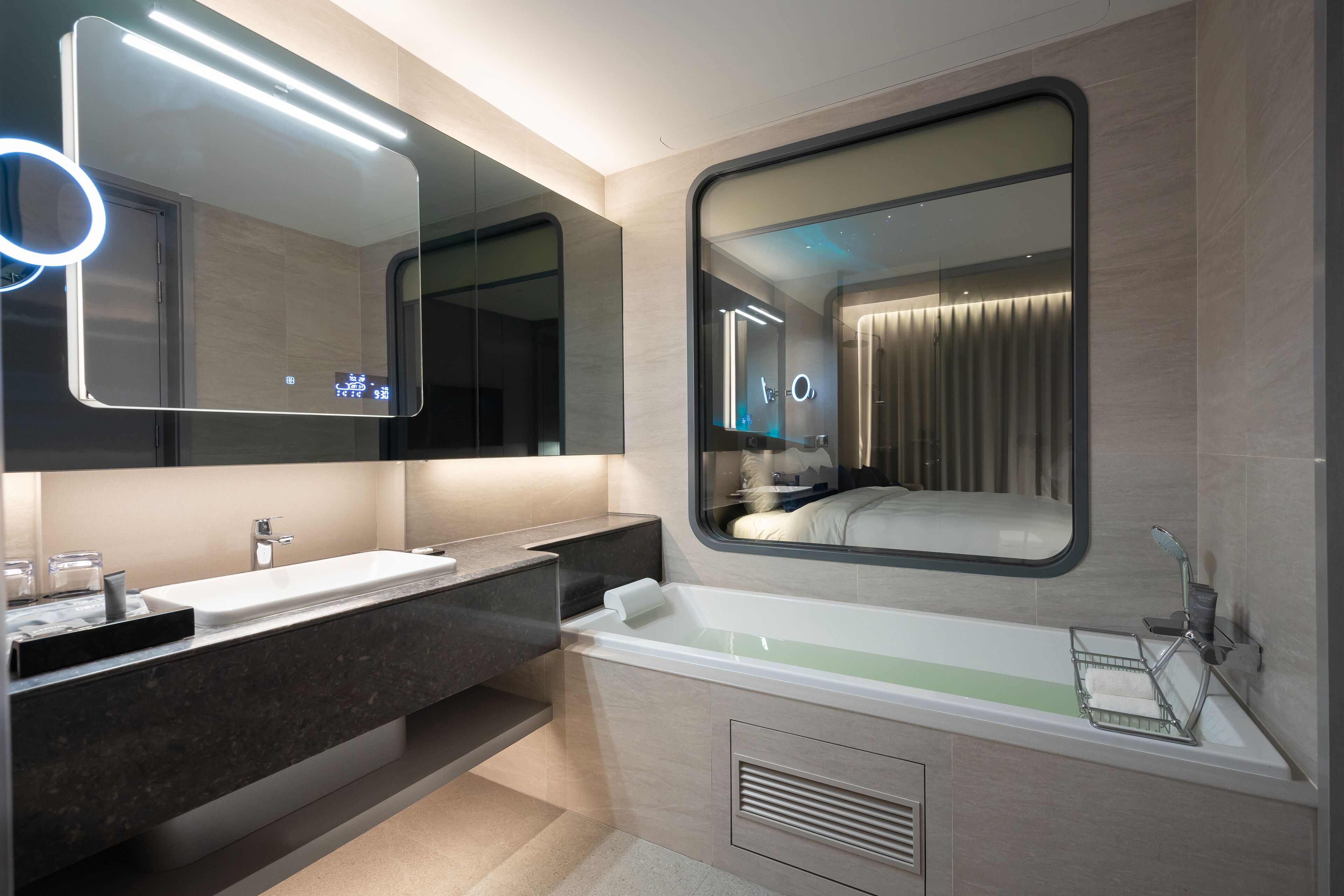 Une salle de bain moderne avec un grand miroir, un lavabo et une baignoire.