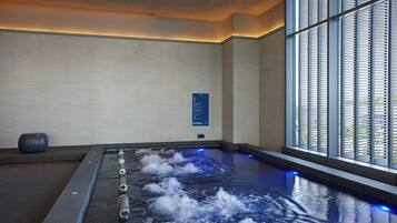 A spa area with a hot tub, a sign indicating room number 1, and a window with blinds.