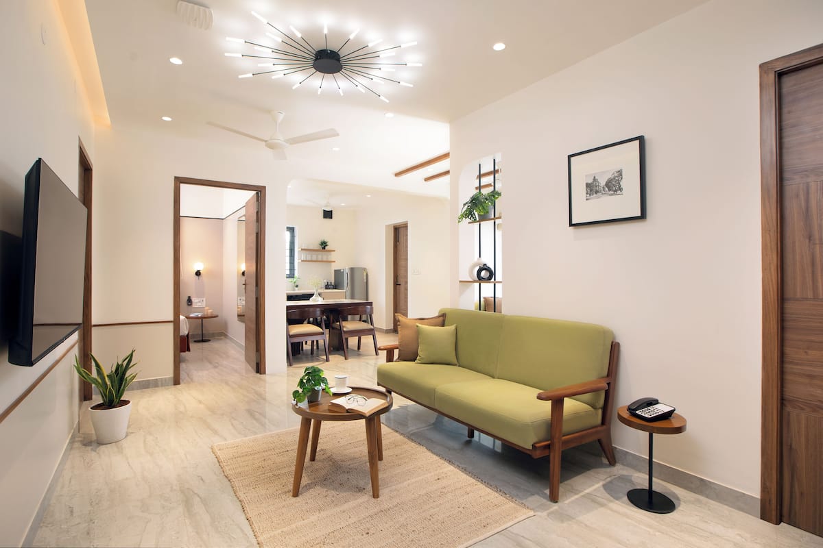 A modern living room with a sofa, coffee table, and a small side table with a phone.