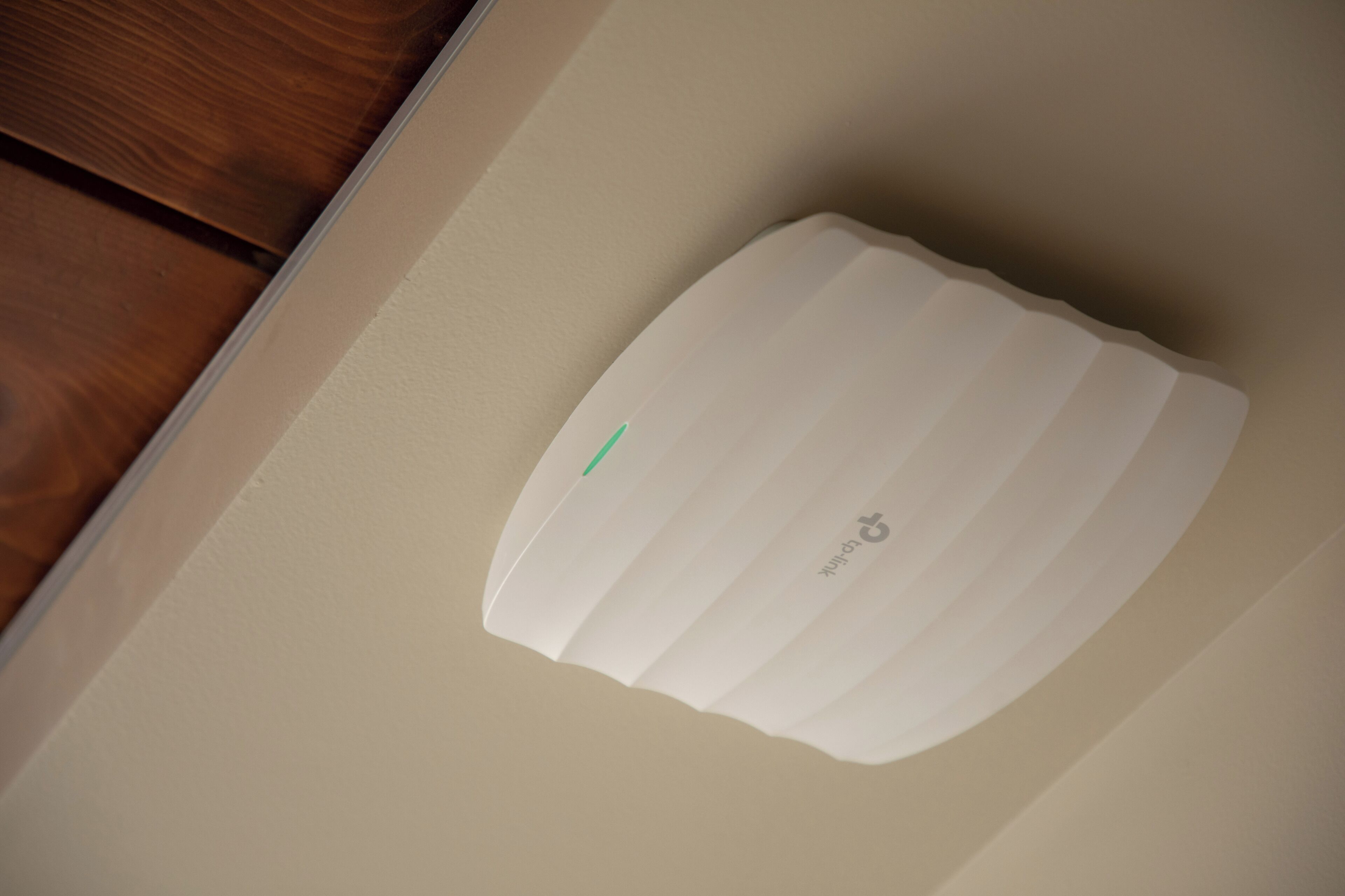 A white, rectangular object with a green stripe, possibly a control panel or device, on a beige wall.