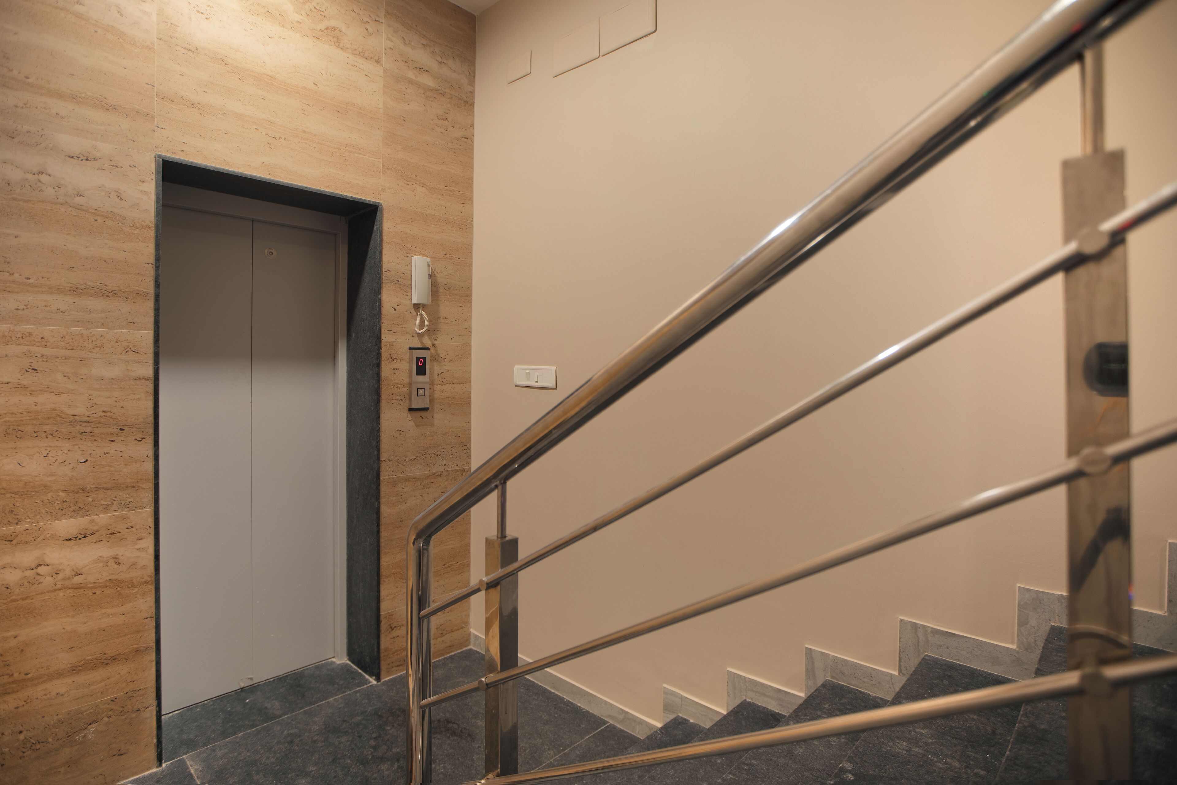 A modern staircase with metal railings and a wooden wall.