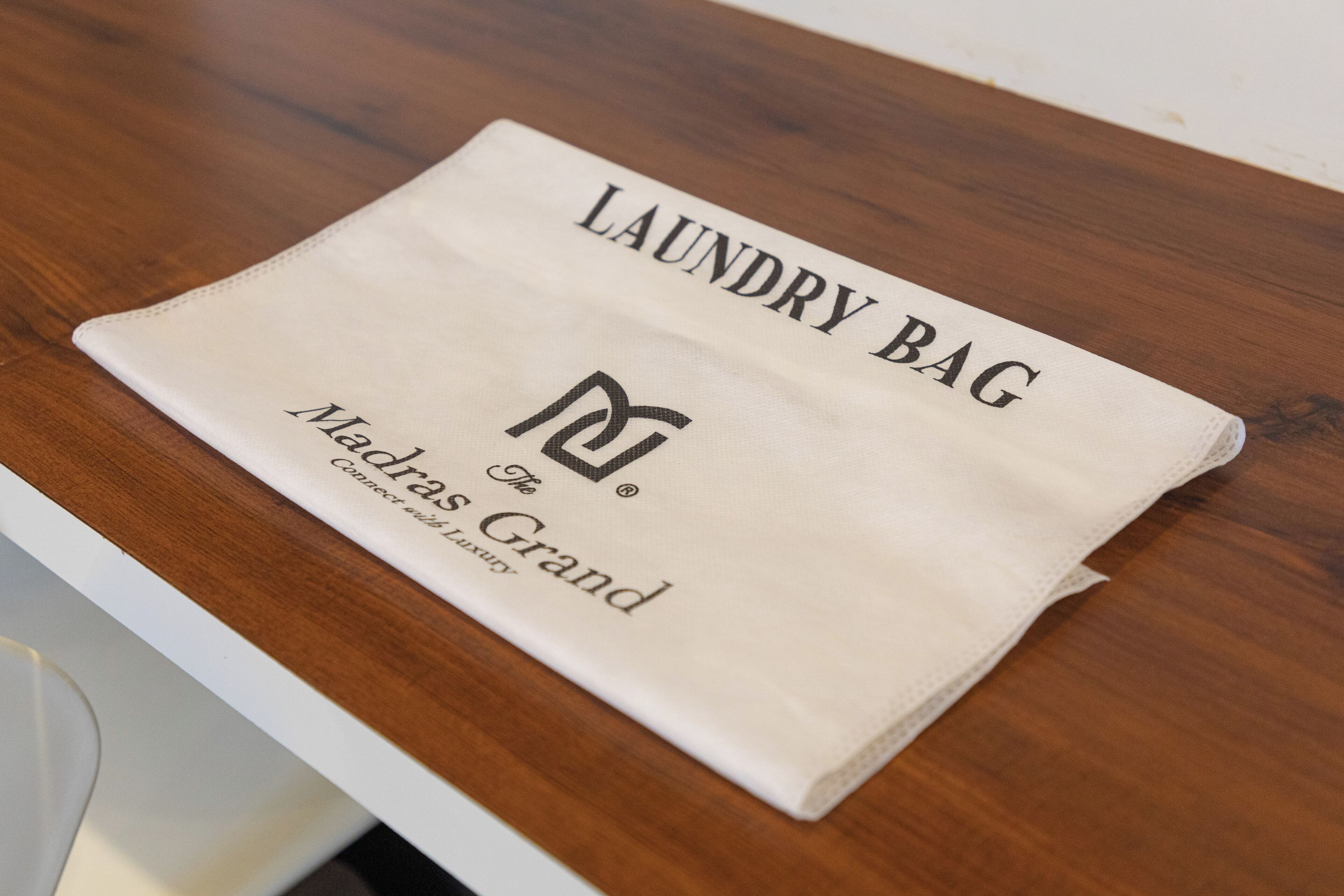 Un sac à linge plié soigneusement, posé sur une surface en bois.