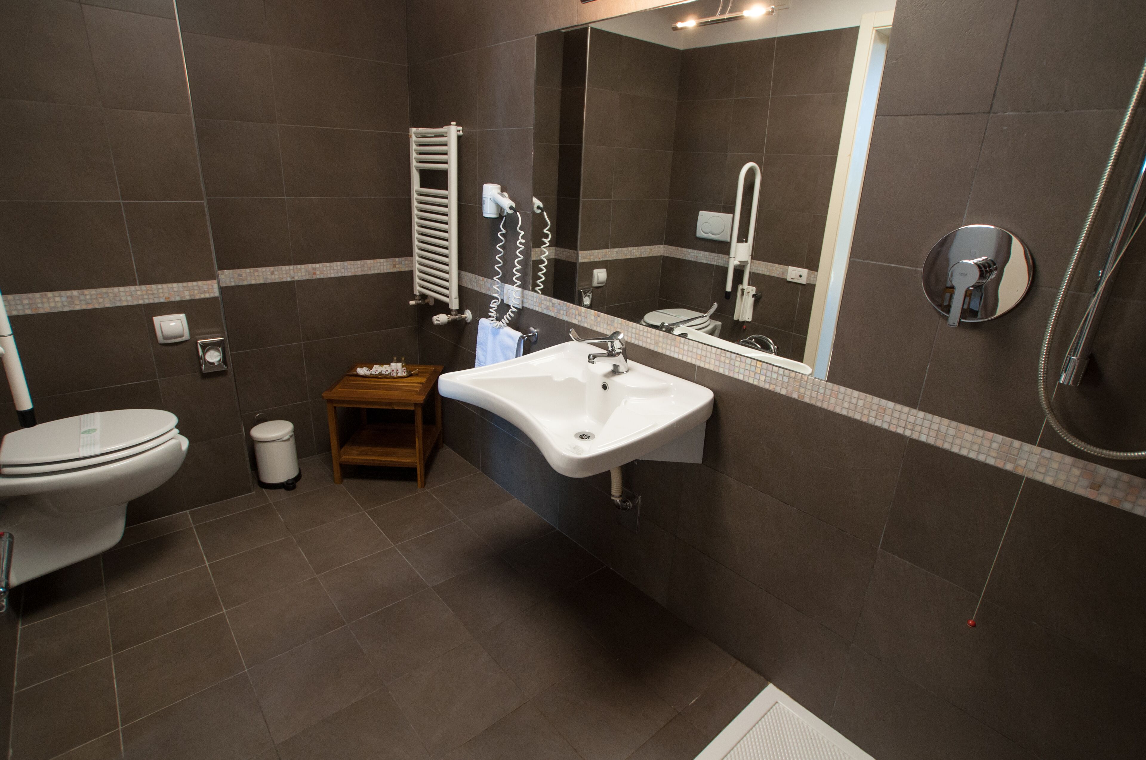 A modern bathroom with a toilet, sink, and shower.