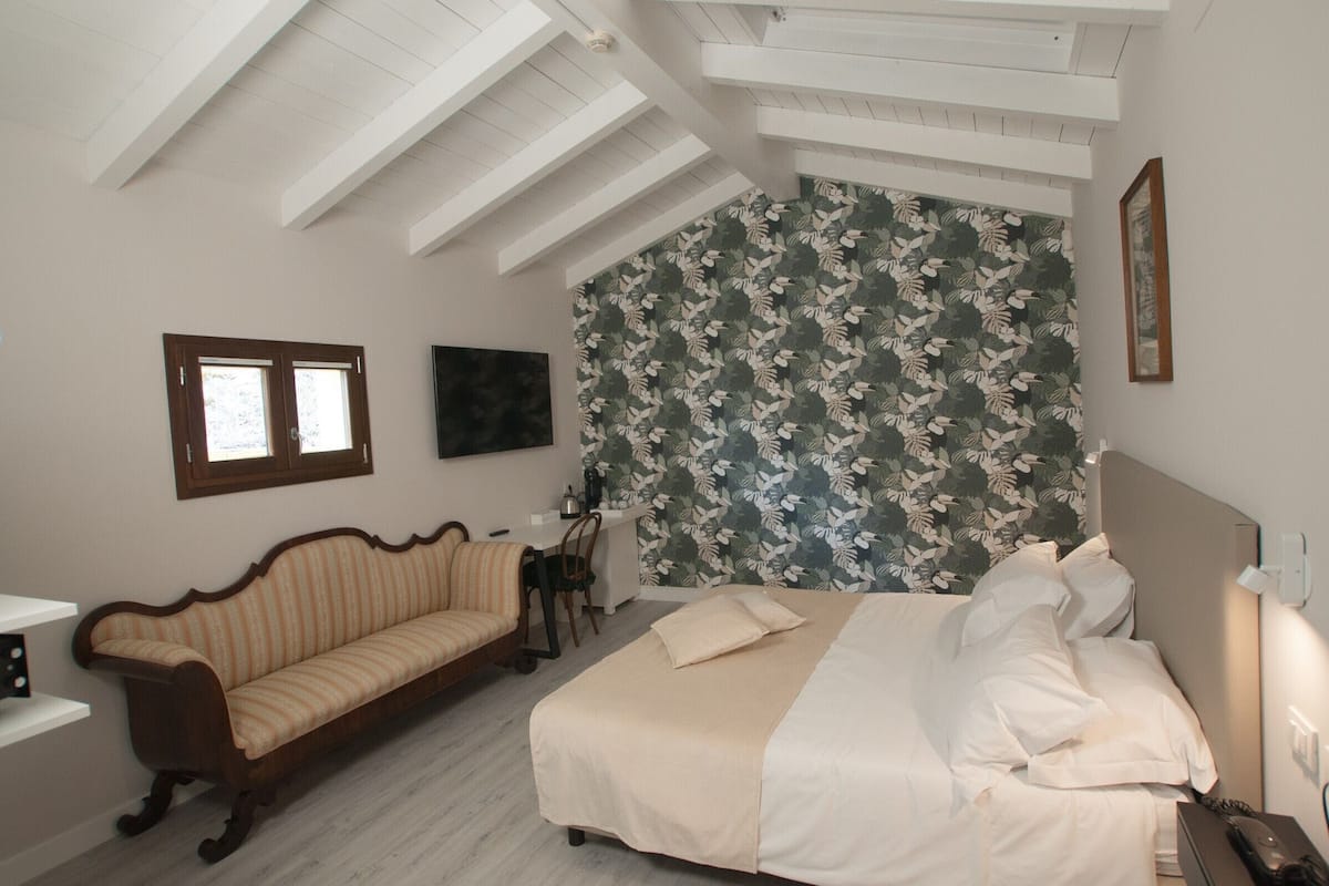 Ein Schlafzimmer mit einem Bett, einem Schlafsofa, einem Schreibtisch und einem Stuhl.