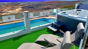 A poolside area with a hot tub, lounge chairs, and a view of the landscape. - Villa Vista Mar II, 280sqm Luxus, HotTube, amazing stunning oecan view, pool (Güime)