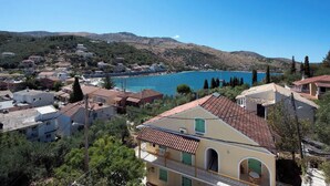 A coastal town with buildings, a clear blue sea, and hills in the background. - Close to the beach, spacious two-bedroom apartment with breakfast (Corfu)