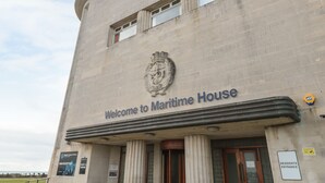 The exterior of Maritime House with a prominent entrance and a crest above the sign. - Lighthouse View (Portland)