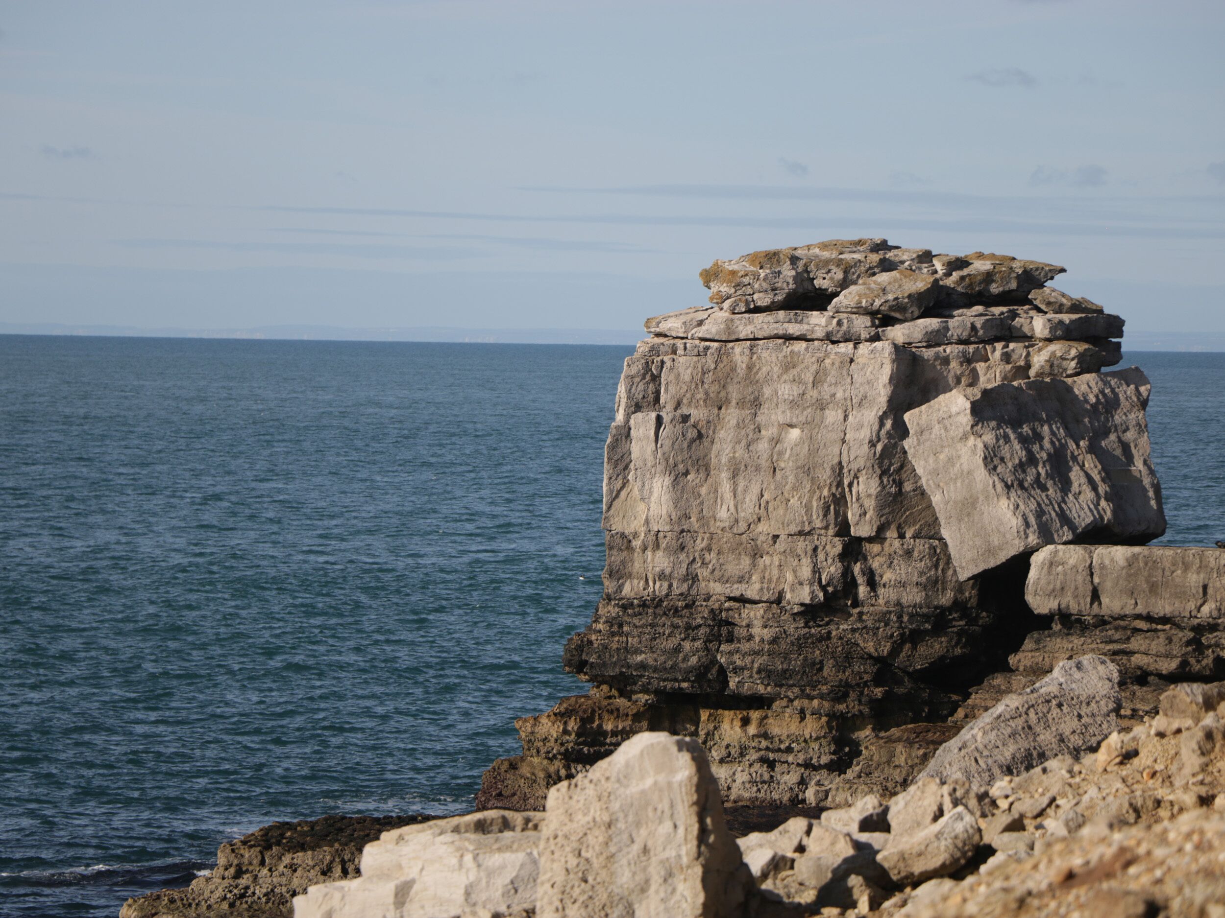 A coastal rock formation with a clear view of the ocean.