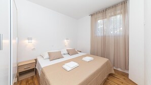Ein Hotelzimmer mit Bett, Nachttischen und einem Fenster mit Vorhängen.