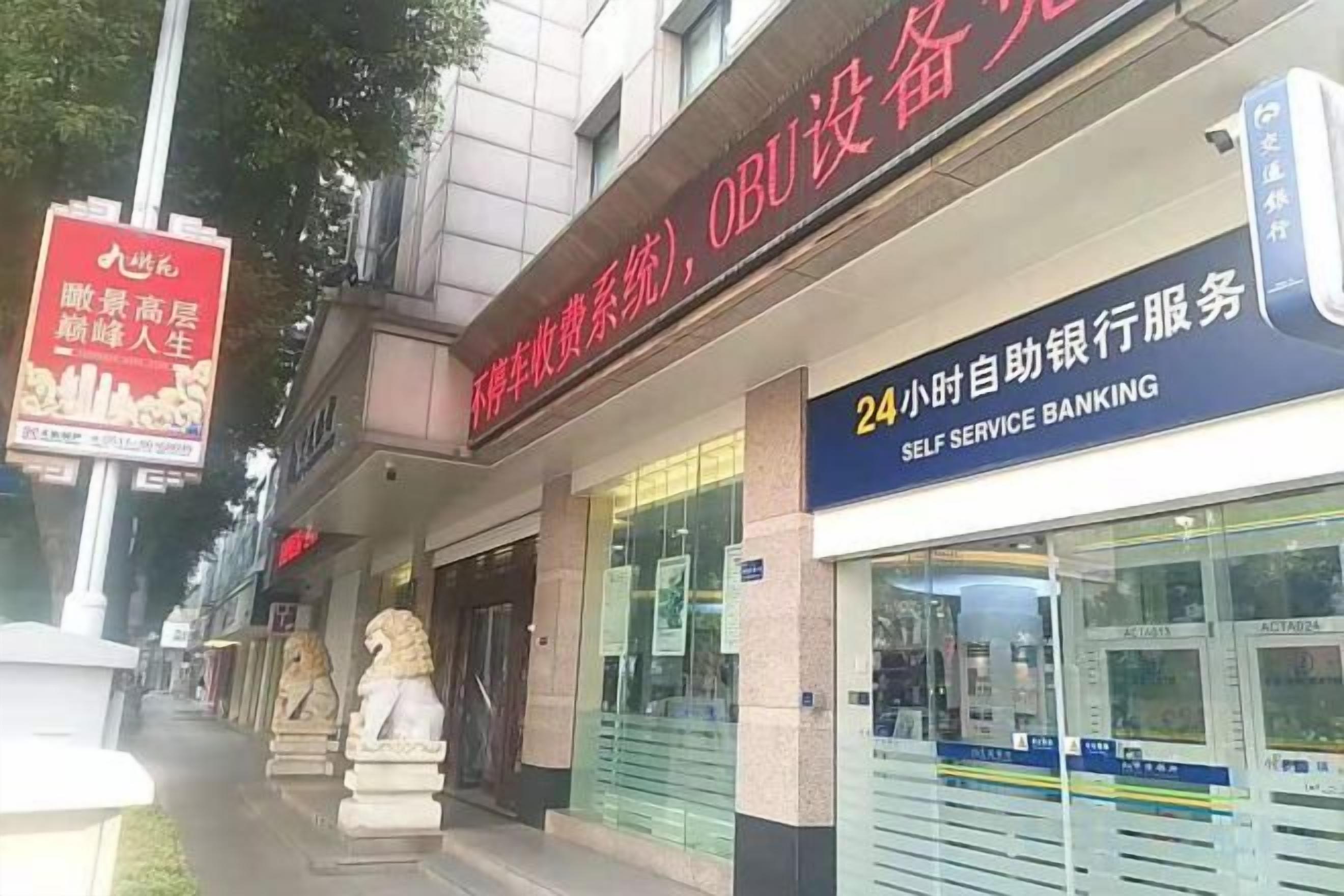 Un bâtiment sur lequel on peut voir une enseigne indiquant un guichet automatique et une autre faisant la publicité d’un restaurant.