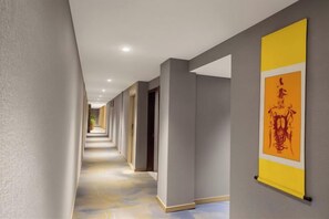 Un couloir doté d’un sol carrelé, de murs gris et d’une banderole jaune avec du texte rouge.