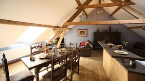 Ein gemütliches Loft mit Essbereich, Küchenzeile und Sitzgelegenheit.