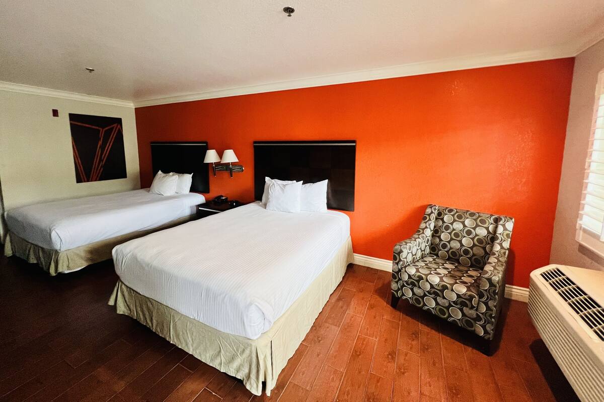 Habitació d'hotel amb dos llits, una cadira i un radiador.