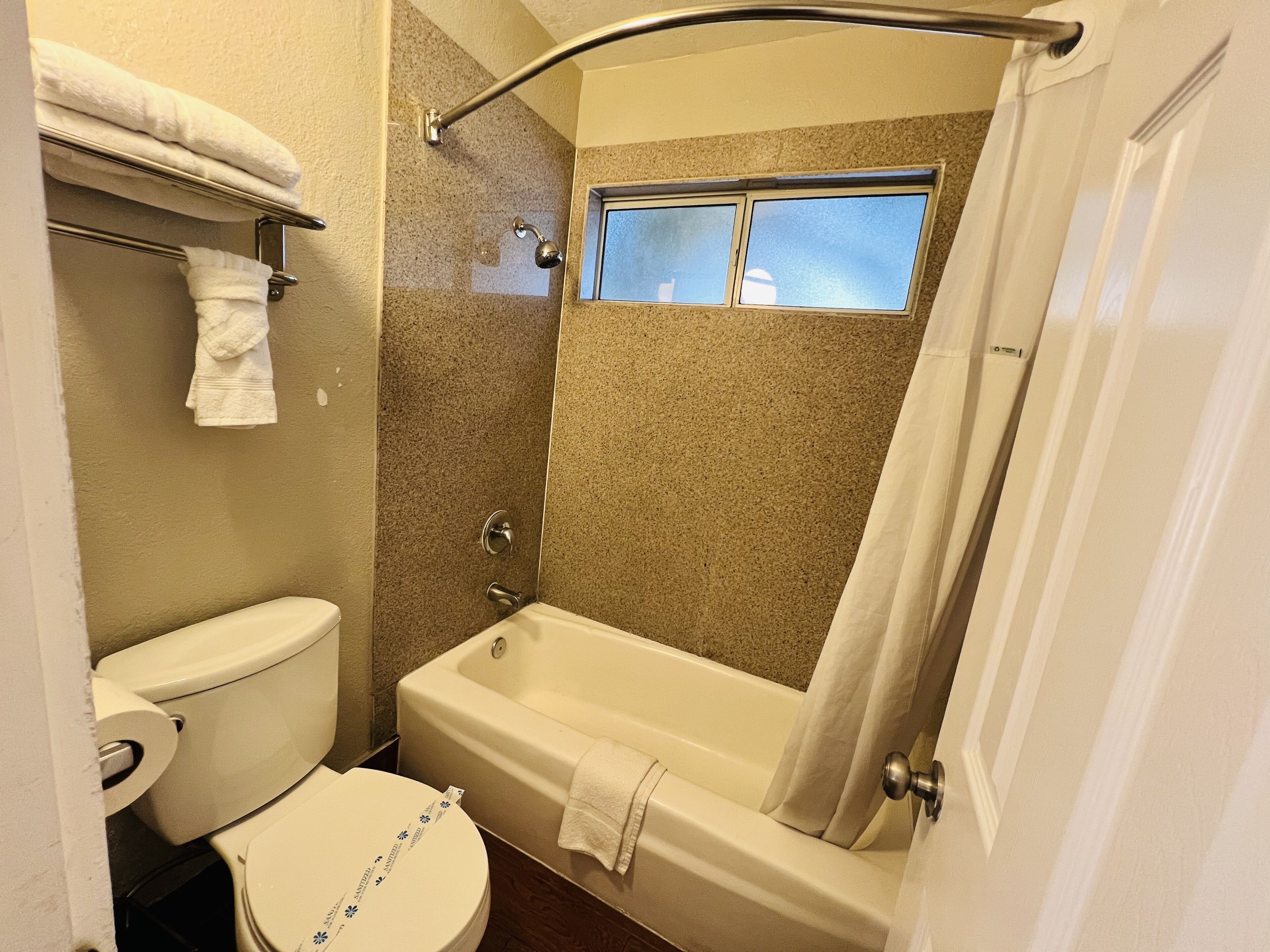 A bathroom with a toilet, bathtub, and shower curtain.