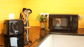 A kitchen with a toaster, microwave, and a potted plant on the counter. - Villa Invicta II (Porto)