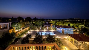 A nighttime view of a resort with a swimming pool, outdoor seating, and well-lit pathways. - Yria ntn Studios (Zakynthos)