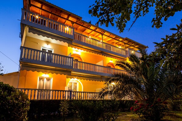 A multi-story building with balconies and a well-lit entrance.