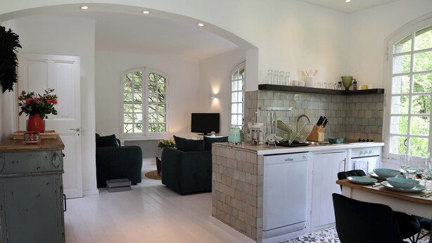 A modern kitchen with a central island, built-in appliances, and large windows. - Villa Mas du Château - Aircon- Private Pool (Villarzel-Cabardès)