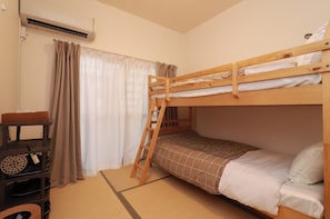 Een stapelbed met een ladder, een plank met schoenen en een futonbed.